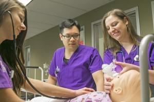 A trio of Concordia University Texas nursing students practicing with a simulated patient